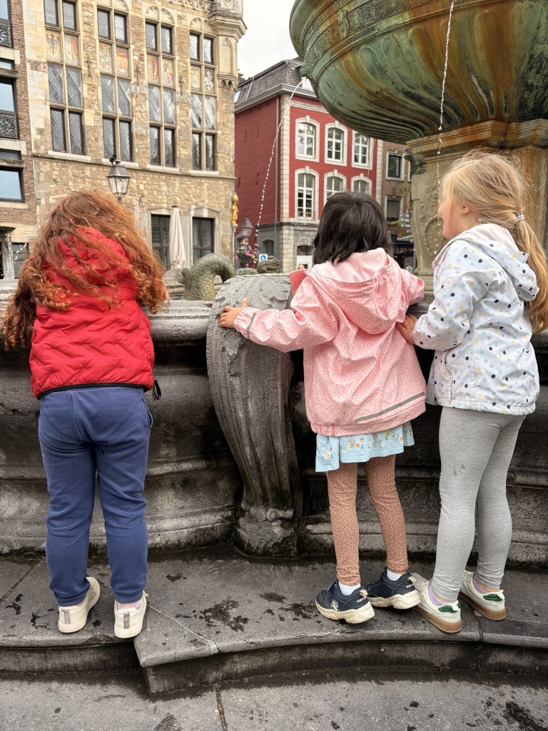 Kinderladenkinder stehen am Marktbrunnen
